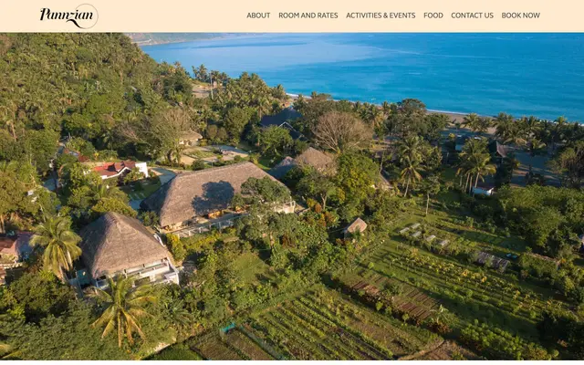 The Pannzian resort home page: an aerial photograph of thatched roof cottages among gardens and palms with the sea beyond, under a cream navigation bar carrying the Pannzian script logo